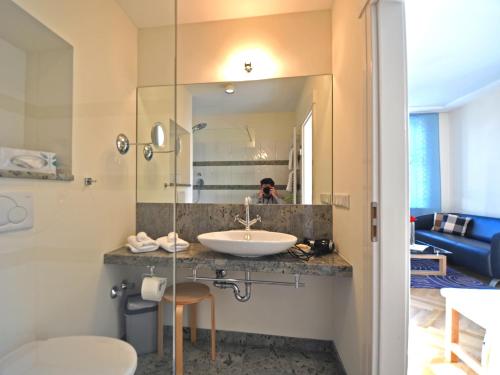 a bathroom with a sink and a mirror at Villa Andante Apartmenthotel in Kassel