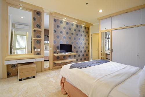 - une chambre avec un grand lit et une télévision dans l'établissement Midtown Residence Simatupang Jakarta, à Jakarta