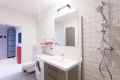 a white bathroom with a sink and a mirror at GRANO APARTMENTS Gdańsk Motława SPA & Wellness in Gdańsk