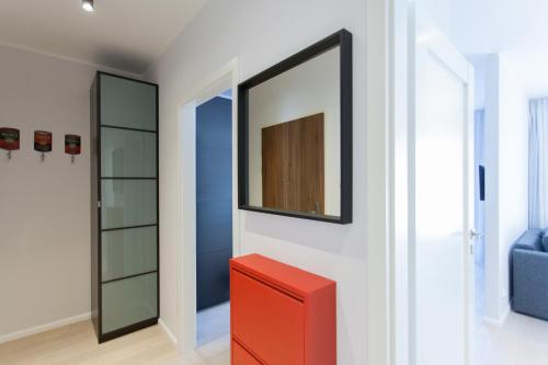 a room with a red drawer and a mirror at GRANO APARTMENTS Gdańsk Motława SPA & Wellness in Gdańsk