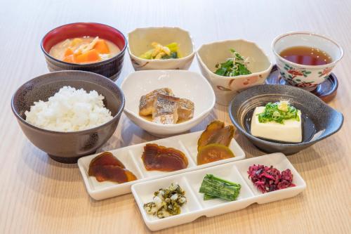 um grupo de tigelas de alimentos com arroz e legumes em Sotetsu Fresa Inn Kyoto-Hachijoguchi em Quioto