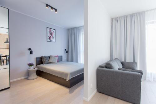 a bedroom with a bed and a couch at GRANO APARTMENTS Gdańsk Motława SPA & Wellness in Gdańsk