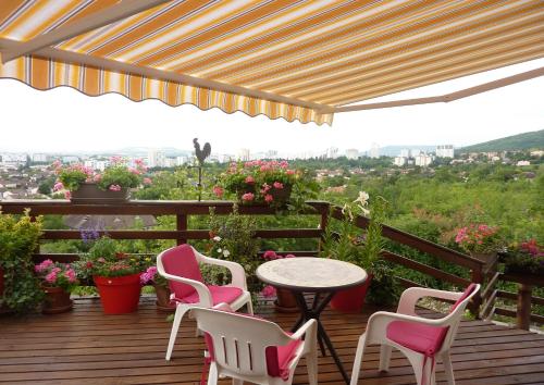a patio with pink chairs and a table on a deck at Les Terrasses de Bellemoure Cébazat in Cébazat