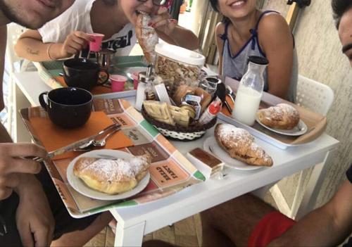 een groep mensen die rond een tafel zitten met eten bij B&B Amina in Pontecagnano