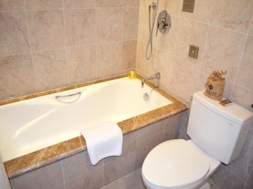 a bathroom with a toilet and a tub and a toilet paper roll at Hui Fu Jinling Hotel in Gaoyou