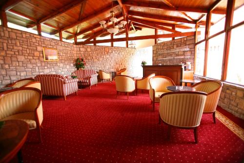 a room with chairs and tables and a brick wall at Hotel Zora in Primošten
