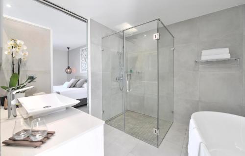 a bathroom with a glass shower and a sink at Le Spinaker in Le Grau-du-Roi