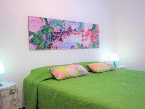 セストリ・レヴァンテにあるCristina Maisonのベッドルーム1室(壁に絵画が描かれた緑のベッド1台付)