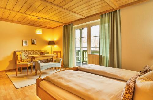 ein Hotelzimmer mit 2 Betten, einem Tisch und Stühlen in der Unterkunft Haus Wiesengrund in Frauenau