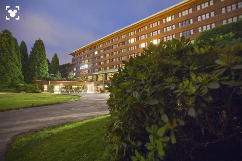 a large building with a parking lot in front of it at Disney Sequoia Lodge in Coupvray