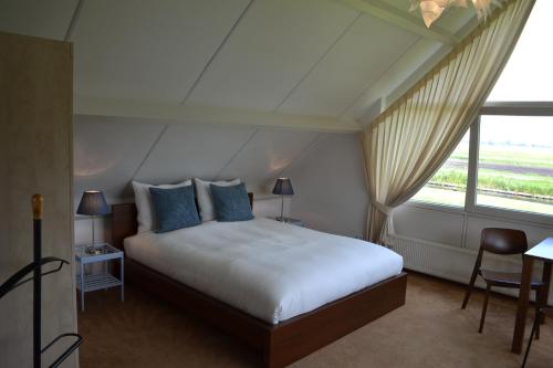 a bedroom with a bed and a large window at Bed & Breakfast Giethoorn in Giethoorn