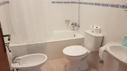 a white bathroom with a toilet and a sink at Villa Mucifal D in Sintra