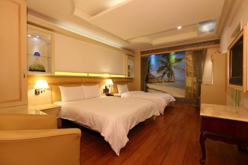 een hotelkamer met 2 bedden en een raam bij Kai Fu Hotel in Taoyuan