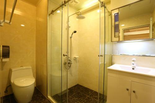 W łazience znajduje się prysznic, toaleta i umywalka. w obiekcie Kai Fu Hotel w mieście Taoyuan