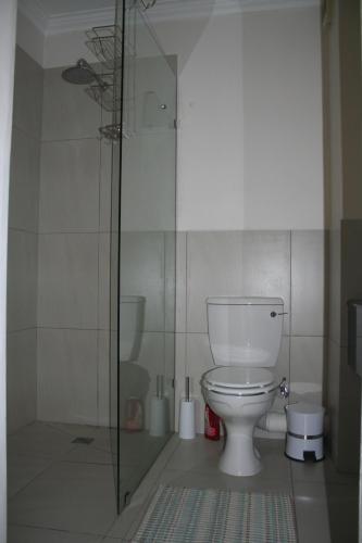 a bathroom with a toilet and a glass shower at Keurbooms River Lodge 21 in Keurboomstrand