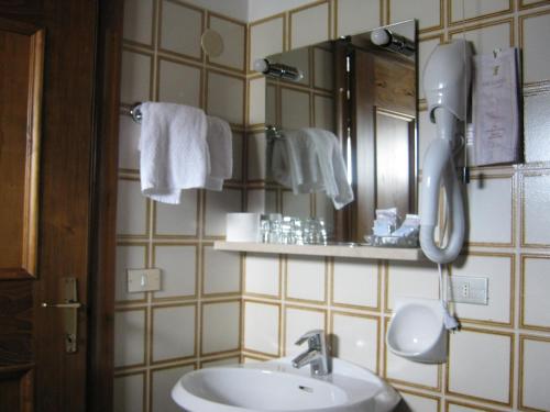 サン・ヴィート・ディ・カドーレにあるHotel Albergo Dolomitiのバスルーム(シンク、鏡、タオル付)