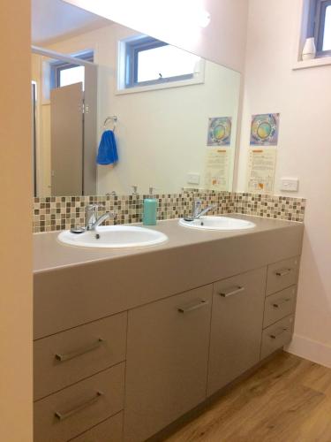 a bathroom with two sinks and a mirror at Gliss Ski Club in Mount Buller