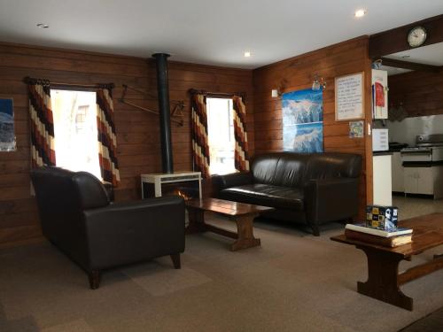 a living room with leather couches and a coffee table at Gliss Ski Club in Mount Buller