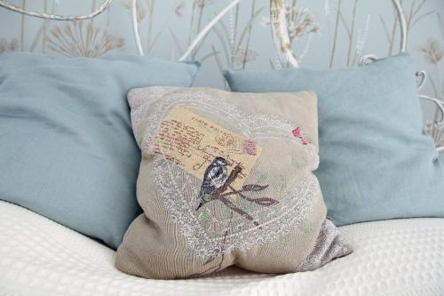 a pillow with a bird on it sitting on a couch at Vánkos in Badacsonyörs