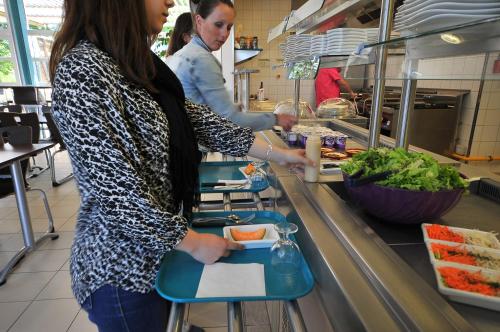 deux femmes debout dans une cuisine préparant la nourriture dans l'établissement Auberge de jeunesse Rochefort, à Rochefort