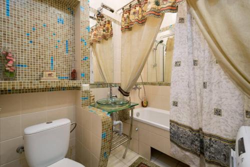 a bathroom with a toilet and a sink and a tub at Nadezhda Apartments in Keremet Microdistrict in Almaty