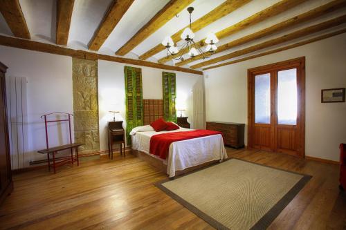 a bedroom with a bed with a red blanket at La Casona de Pitillas in Pitillas