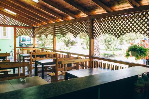 um restaurante vazio com mesas e bancos de madeira em Berizka em Perechin