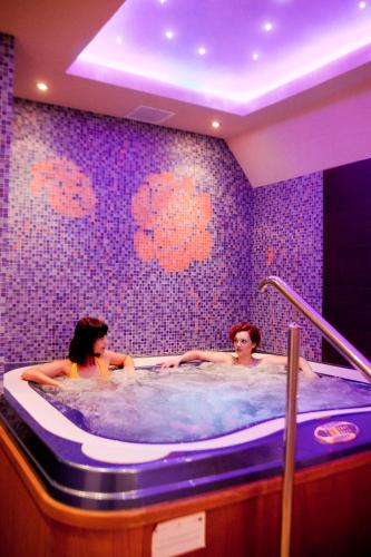two women in a hot tub in a bathroom at Centrum Green Hill Business & SPA in Wisła