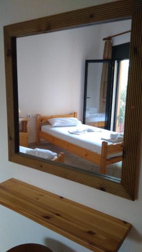 a mirror on a wall with a bed in a room at Nikolitsa Apartments in Glyfada Fokidas