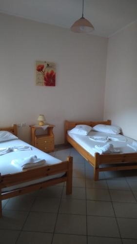 a room with two beds and a table with a picture at Nikolitsa Apartments in Glyfada Fokidas