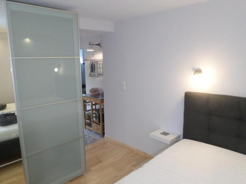 a bedroom with a glass shower door next to a bed at Ferienwohnung DAHEIMchen in Glücksburg