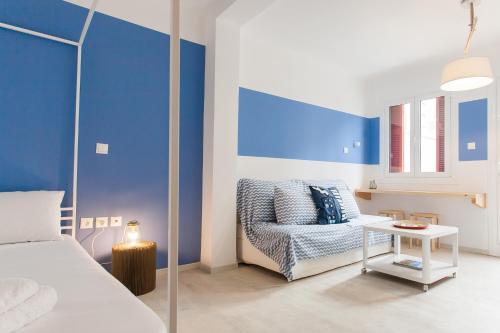 um quarto com paredes azuis, uma cama e uma mesa em Karitsi Place em Atenas