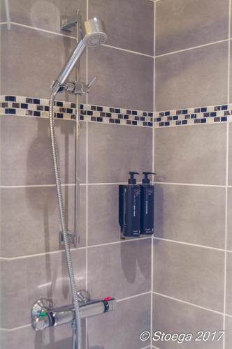 eine Dusche in einem Badezimmer mit gefliester Wand in der Unterkunft B&B Stoega in Brügge
