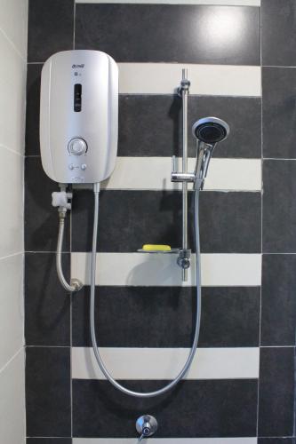 a shower in a bathroom with black and white stripes at Firina Home in Kuala Lumpur