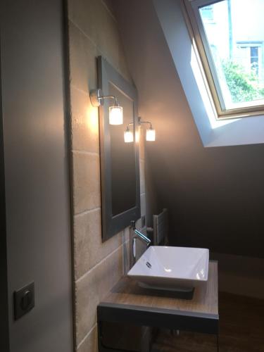 La salle de bains est pourvue d'un lavabo, d'un miroir et d'une fenêtre. dans l'établissement Maison Joséphine avec garage privé, à Blois