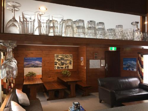 a room with a table and glasses on a shelf at Gliss Ski Club in Mount Buller