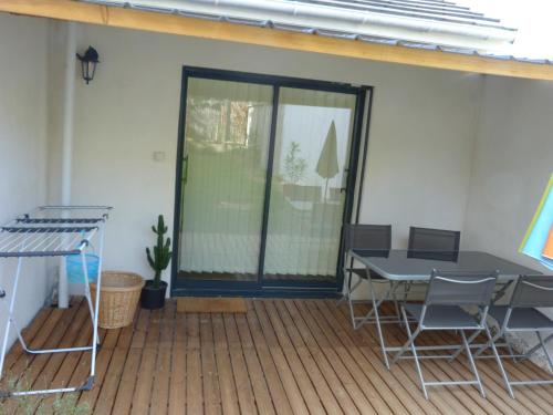 un patio con mesa y sillas en una terraza en Holidays in Paris Loft design & atypique avec jardin en Massy