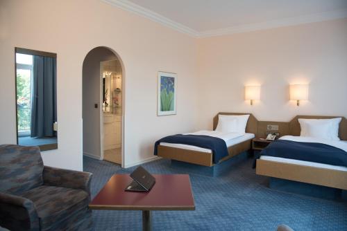 A bed or beds in a room at Parkhotel Bad Homburg