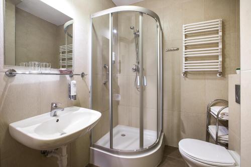La salle de bains est pourvue d'une douche, d'un lavabo et de toilettes. dans l'établissement Hotel Concordia, à Podgórzyn