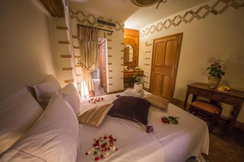 a bedroom with a white bed with flowers on it at Dar victoria in Fès