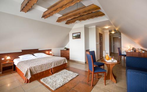 a bedroom with a bed and a table and chairs at Hotel Concordia in Podgórzyn