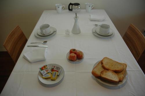 einen Tisch mit einem Teller Brot und einem Obstteller in der Unterkunft La Fustana in Maia de Montcal