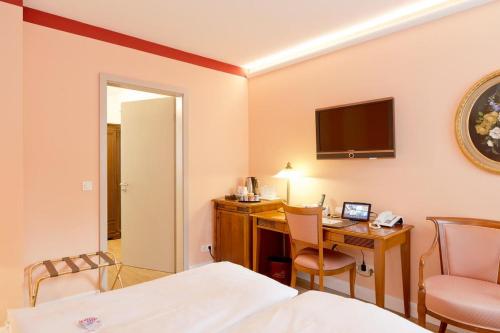 a hotel room with a desk and a bed and a computer at Hotel Villa Monte Vino in Potsdam