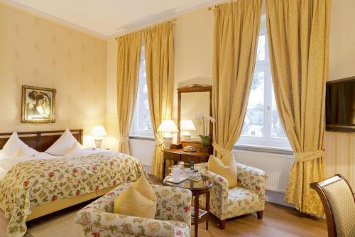 a hotel room with a bed and two chairs at Hotel Villa Monte Vino in Potsdam