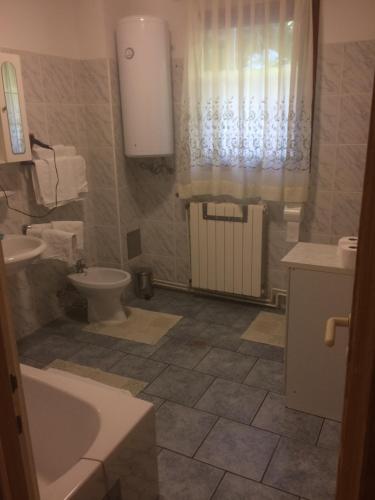 a bathroom with a sink and a toilet and a tub at Toni i Kristina in Baška
