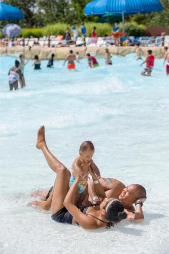 a woman and a man and a child in a swimming pool at The Appalachian at Mountain Creek in Vernon