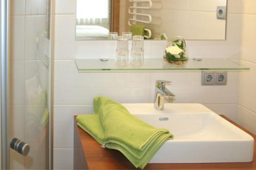 ein Badezimmer mit einem Waschbecken und einem grünen Handtuch darauf in der Unterkunft Hauerwirt in Sankt Peter am Wimberg