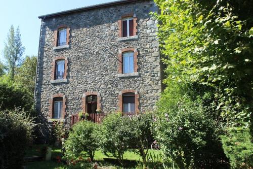 an old stone house with trees in front of it at Aucairn in Château-Verdun