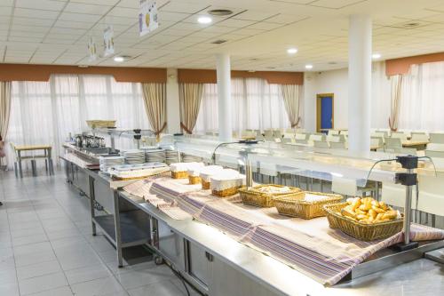 eine Cafeteria mit einem Buffet mit Speisen in der Unterkunft Albergue Inturjoven Sevilla in Sevilla