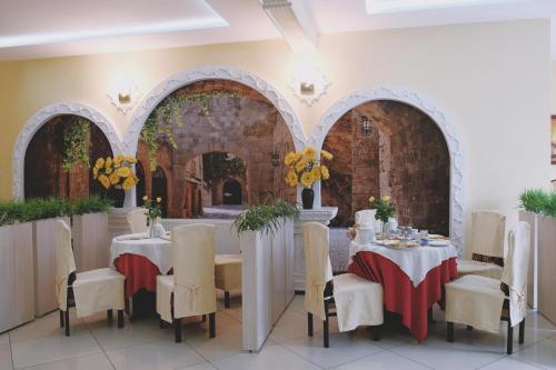 a dining room with tables and chairs and arches at Zajazd Restauracja Paradise in Czaplinek